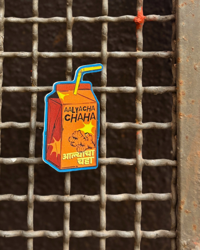 Sticker shaped like a juice carton, chai, with text on a metal grid background