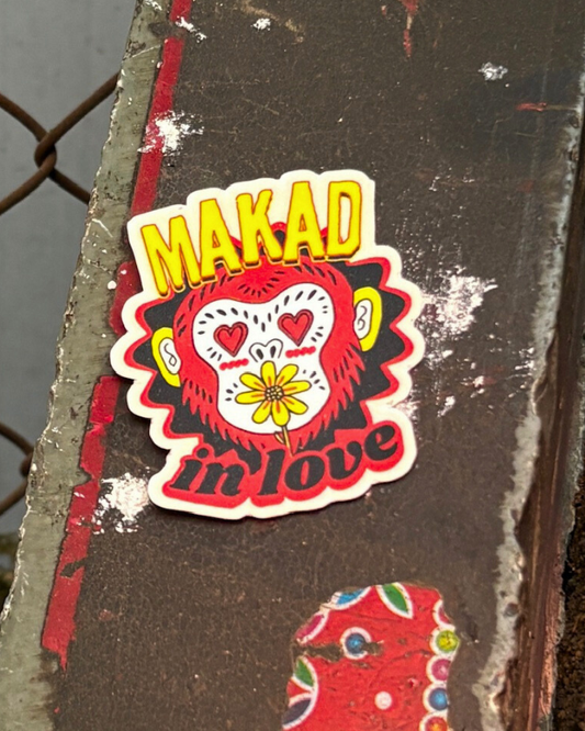 Sticker with 'MAKAD in love' design on a textured surface