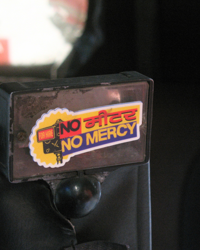 Sticker with 'No Mercy' text on a black surface, rickshaw pune